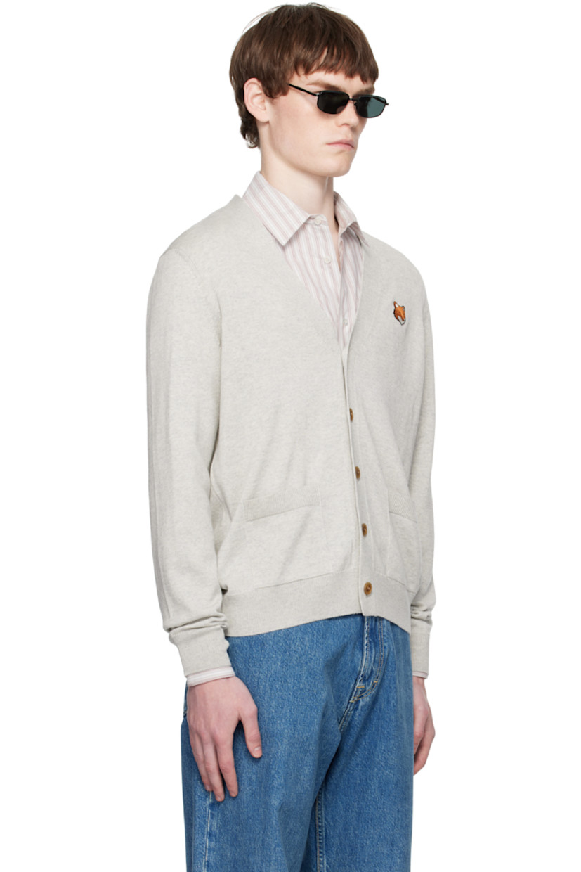 Knit wool cardigan.

· Rib-knit Y-neck, hem, and cuffs
· Button closure
· Embroidered logo patch at chest
· Patch pockets at front

Supplier color: Light grey melange