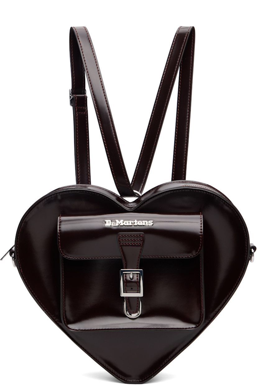 Heart-shaped buffed faux-leather backpack.

· Adjustable and detachable sliding shoulder strap
· Strap converts to crossbody
· Logo hardware and flap pocket at face
· Card slot at back face
· Twill lining
· H9.5" x W12" x D3"

Supplier color: Cherry red arcadia/Oxford rub off