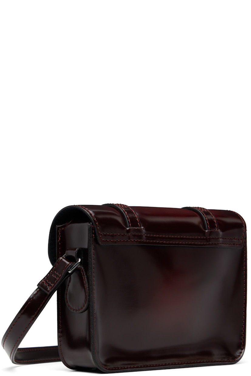 Polished faux-leather shoulder bag.

· Adjustable crossbody strap
· Logo hardware at face
· Pin-buckle tabs at magnetic press-stud flap
· Twill lining
· Logo-engraved silver-tone hardware
· H5" x W7" x D2"

Supplier color: Cherry red