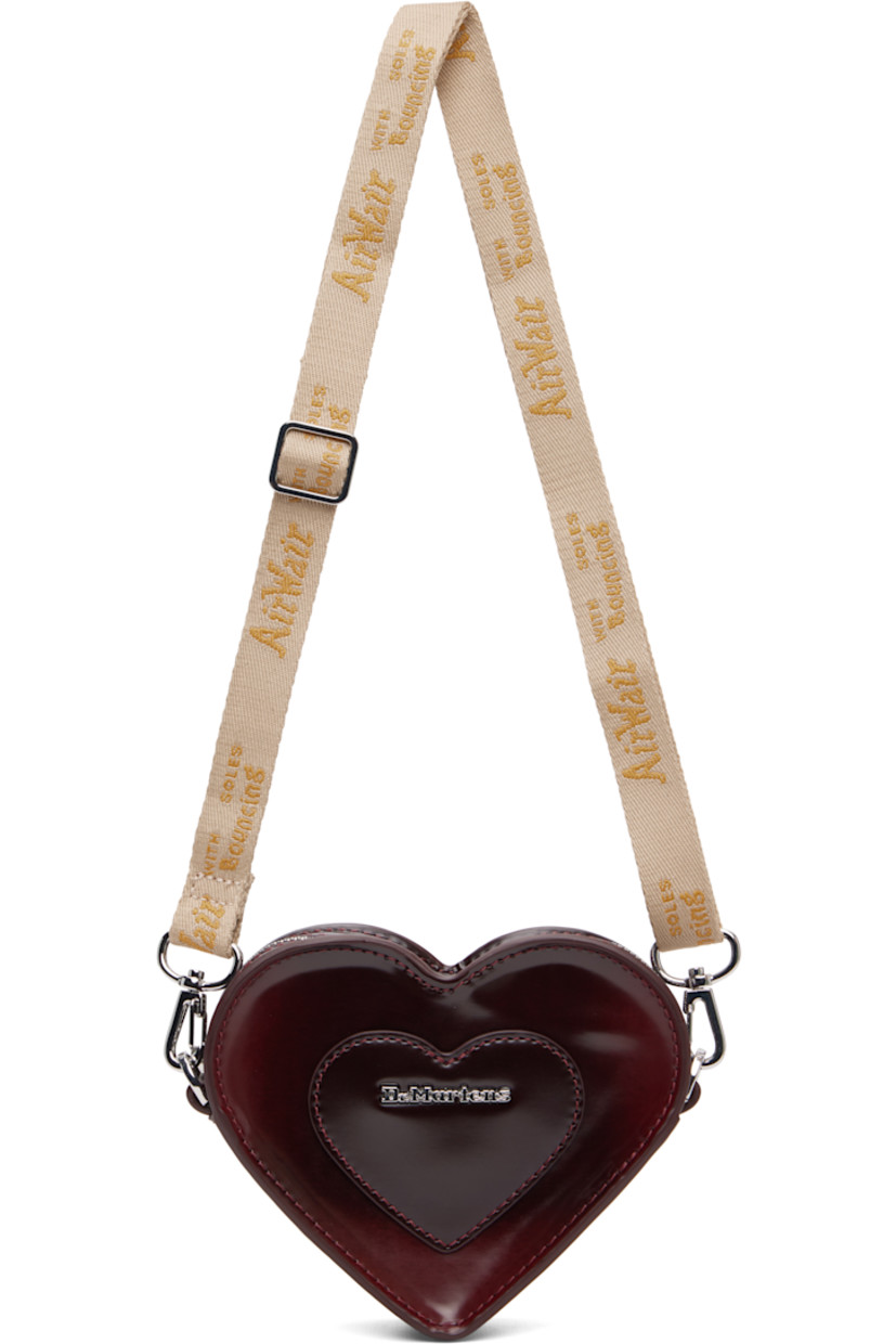Heart-shaped buffed faux-leather shoulder bag.

· Adjustable and detachable crossbody strap
· Alternate detachable crossbody chain
· Logo hardware and graphic appliqué at face
· Zip closure
· Card slot at interior
· Twill lining
· H4.5" x W6" x D1.5"

Supplier color: Oxford rub off