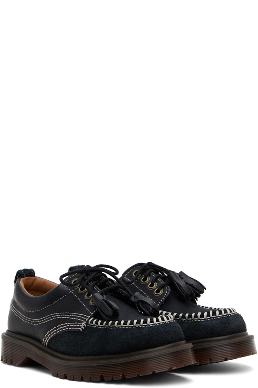 Buffed leather, nubuck, and suede derbys in black.

· Blanket stitching at moc toe
· Tassels at lace-up closure
· Padded collar
· Pull-loop at heel collar
· Buffed leather and suede lining
· Serrated detailing at heat-sealed Goodyear welt
· Treaded Air Cushion rubber sole
· Contrast stitching in white

Supplier color: Black kinsley tumble