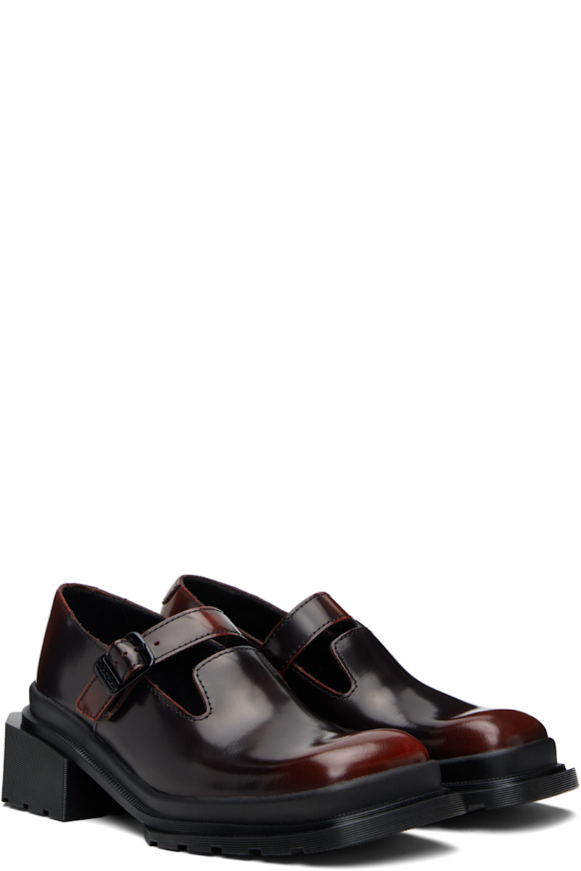 Polished leather Mary Jane-style heels.

· Square toe
· Pin-buckle strap at vamp
· Rubber block heel
· Serrated edge at welt
· Treaded Air Cushion rubber sole
· Heel: H1.75"

Supplier color: Black/Cherry red arcadia