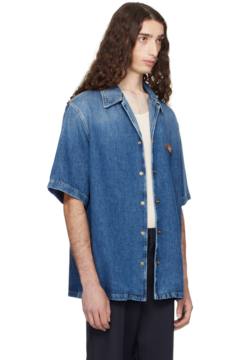 Stonewashed non-stretch denim shirt. Fading throughout.
 
· Lightweight
· Open spread collar
· Press-stud closure
· Leather strap with Medusa charm at chest
· Vented side seams
· Contrast stitching in tan

Part of the La Vacanza collection.

Supplier color: Medium blue