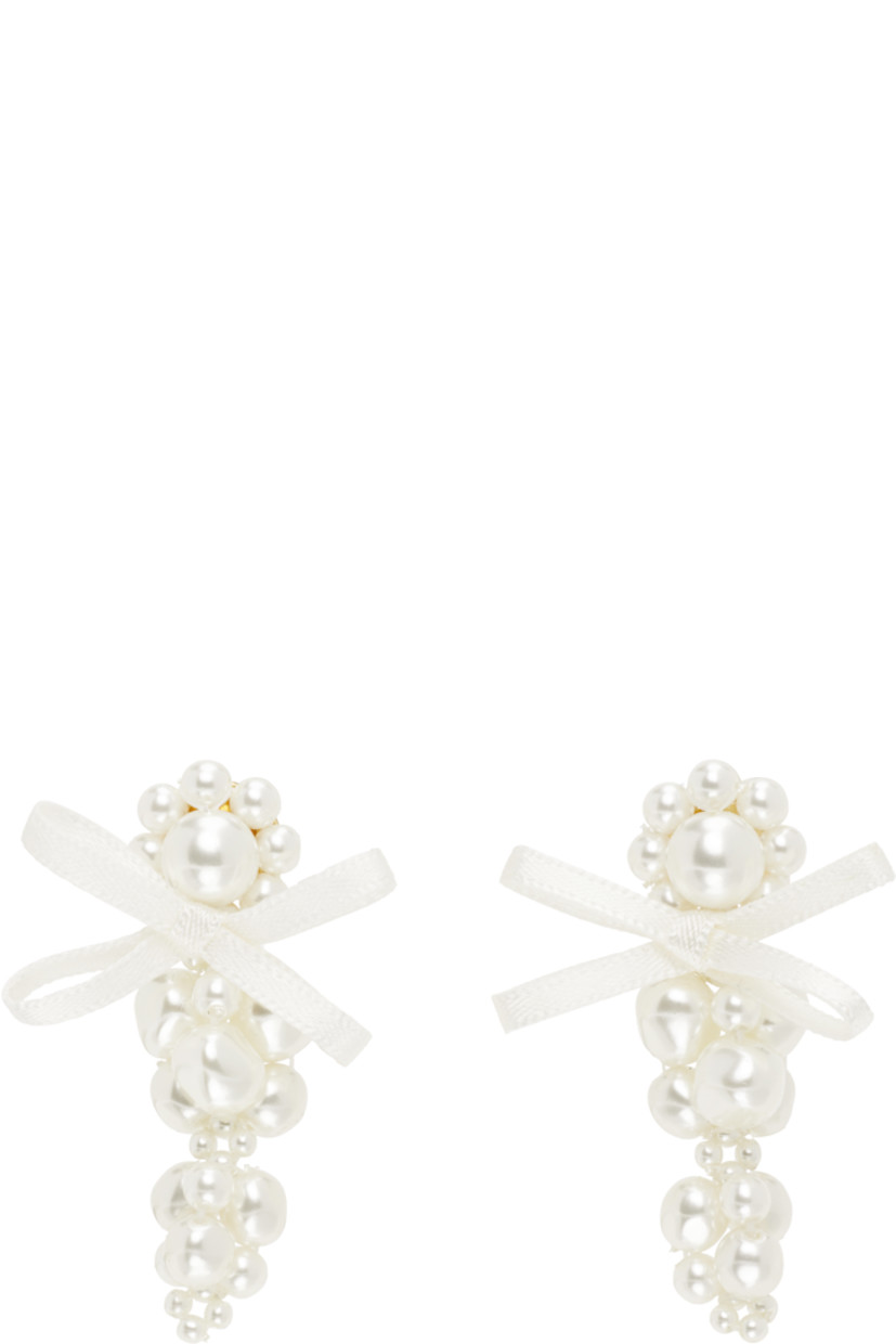 Pair of beaded faux-pearl drop earrings.

· Bow appliqué at face
· Post-stud fastening
· Gold-tone brass hardware
· H2" x W1"

Supplier color: Pearl