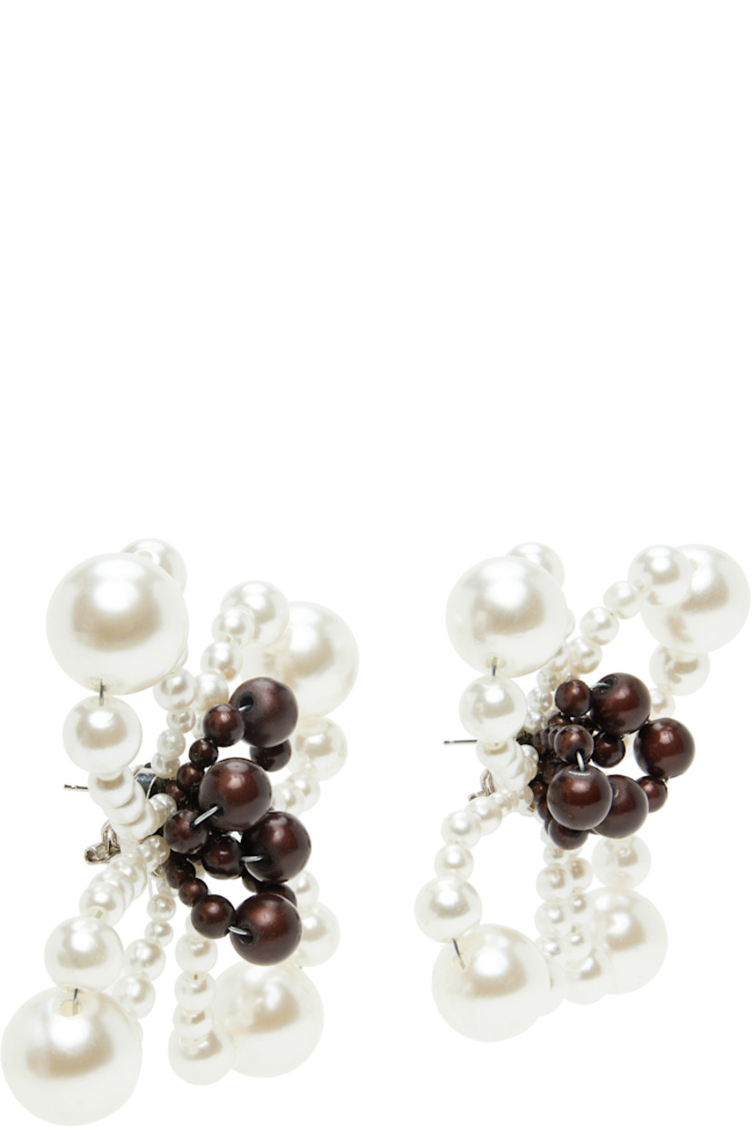 Pair of handcrafted drop earrings in brown and white resin.

· Beaded floral graphic at face
· Silver-tone brass post-stud fastening 
· D3.5"

Supplier color: Pearl/Reflective brown