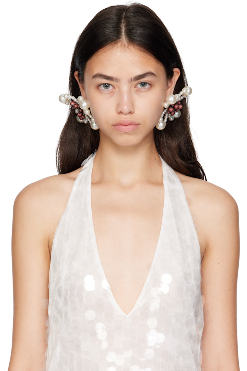 Pair of handcrafted drop earrings in brown and white resin.

· Beaded floral graphic at face
· Silver-tone brass post-stud fastening 
· D3.5"

Supplier color: Pearl/Reflective brown