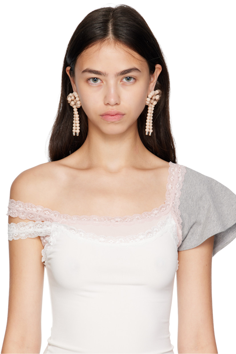 Pair of drop earrings in galvanized steel. 

· Beaded resin bow in pink at face
· Silver-tone brass post-stud fastening 
· H3.25" x W3"

Supplier color: Jade/Off white
