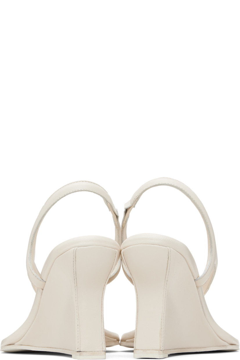 Buffed leather heeled sandals.

· Square toe
· Thong-style strap with stud at vamp
· Partially elasticized slingback strap
· Logo embossed at padded footbed
· Covered wedge heel with rubber injection
· Leather sole
· Heel: H3.5"

Supplier color: Cream