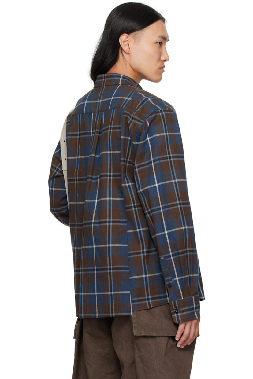 Cotton flannel shirt. 

· Check pattern throughout 
· Spread collar 
· Button closure
· Flap pockets at chest
· Shirttail hem
· Pleats at buttoned barrel cuffs
· Box pleat at back yoke

Supplier color: Brown/Blue