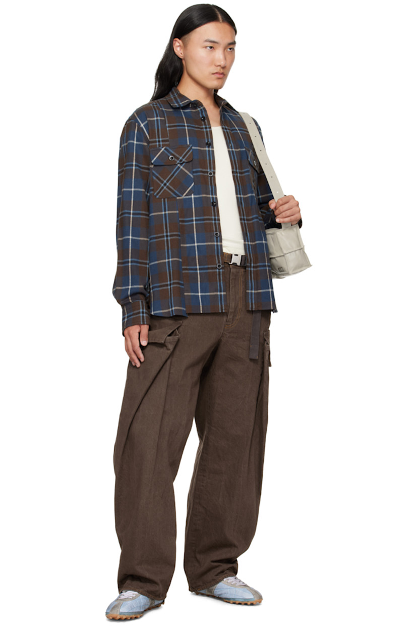 Cotton flannel shirt. 

· Check pattern throughout 
· Spread collar 
· Button closure
· Flap pockets at chest
· Shirttail hem
· Pleats at buttoned barrel cuffs
· Box pleat at back yoke

Supplier color: Brown/Blue