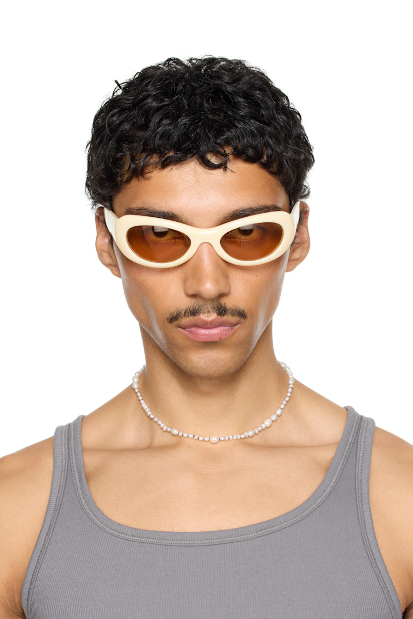 Handcrafted oval cat-eye semi-transparent acetate-frame sunglasses in beige. 

· Orange lenses
· 100% UVA/UVB protection 
· Integrated nose pads
· Rivets at temples
· Semi-exposed core wires 
· Includes pouch
· Size: 53.21 135

Part of the exclusive SSENSE HEAT capsule.

Supplier color: Ivory/Amber