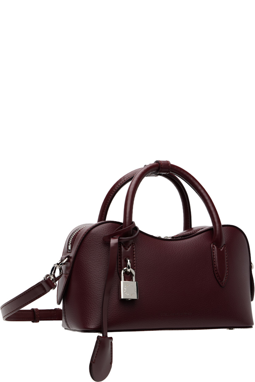 Handcrafted grained faux-leather top handle bag.

· Post-stud tab at rolled carry handles
· Detachable logo-embossed sheathed key at handle
· Adjustable and detachable crossbody strap
· Padlock and embossed logo at face
· Bumper studs at base
· Two-way zip closure
· Patch pocket at interior
· GOTS-certified canvas lining
· H5" x W9.5" x D3.5"

Made from cruelty-free, non-animal materials.

Supplier color: Bordeaux