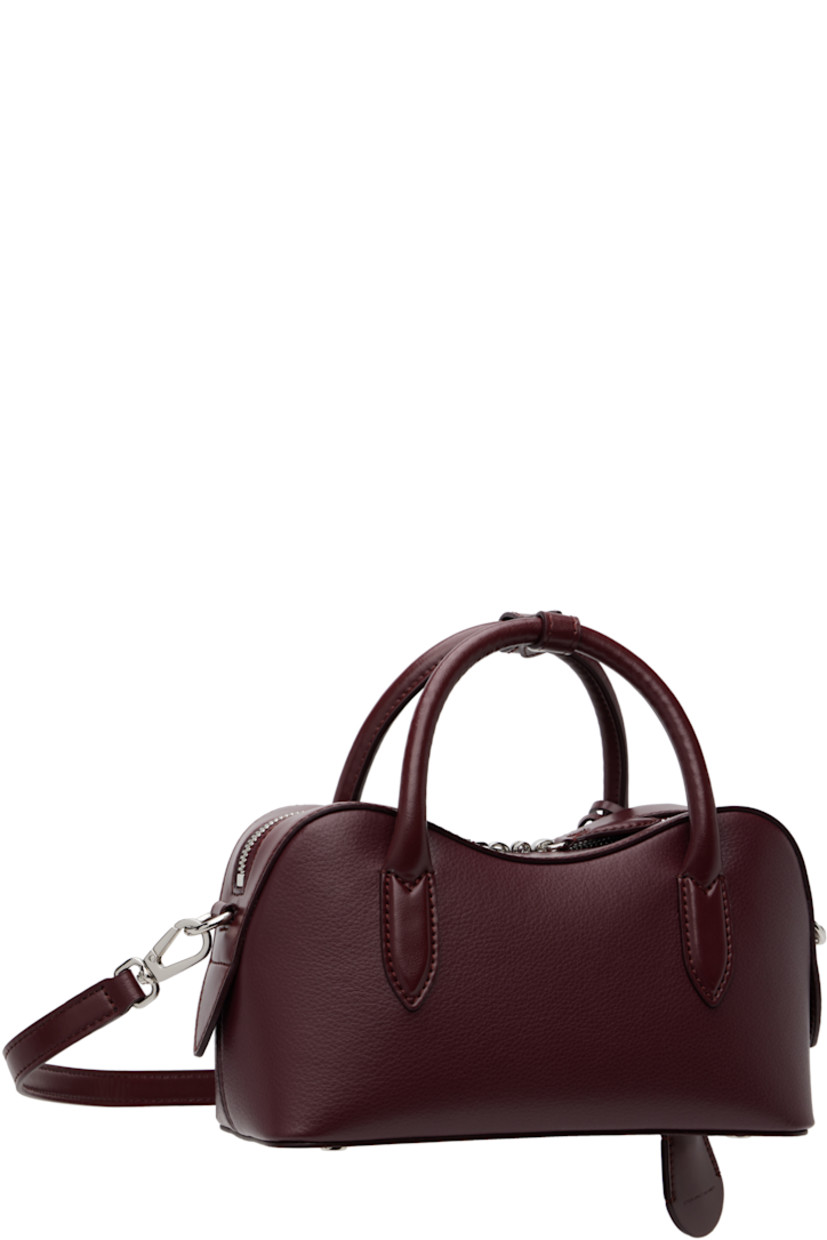 Handcrafted grained faux-leather top handle bag.

· Post-stud tab at rolled carry handles
· Detachable logo-embossed sheathed key at handle
· Adjustable and detachable crossbody strap
· Padlock and embossed logo at face
· Bumper studs at base
· Two-way zip closure
· Patch pocket at interior
· GOTS-certified canvas lining
· H5" x W9.5" x D3.5"

Made from cruelty-free, non-animal materials.

Supplier color: Bordeaux
