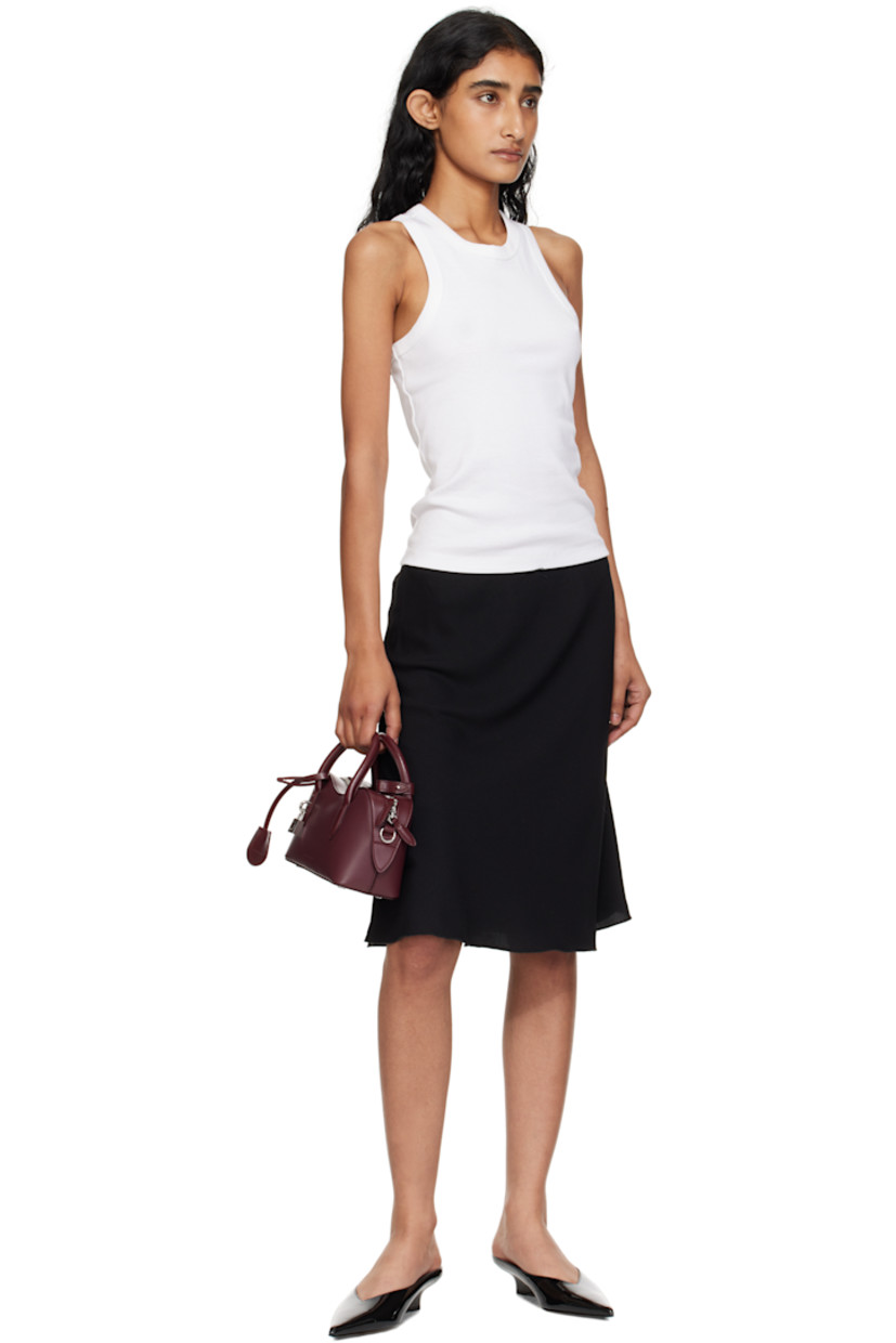 Handcrafted grained faux-leather top handle bag.

· Post-stud tab at rolled carry handles
· Detachable logo-embossed sheathed key at handle
· Adjustable and detachable crossbody strap
· Padlock and embossed logo at face
· Bumper studs at base
· Two-way zip closure
· Patch pocket at interior
· GOTS-certified canvas lining
· H5" x W9.5" x D3.5"

Made from cruelty-free, non-animal materials.

Supplier color: Bordeaux