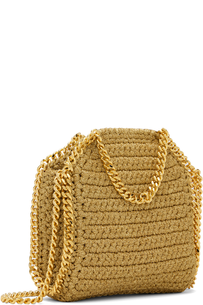Crocheted lurex cord shoulder bag. 

· Curb chain trim throughout
· Curb chain carry handles and shoulder strap
· Logo disc at strap base
· Magnetic press-stud closure
· Patch pocket at interior
· Unlined
· H7" x W6" x D2.5" 

Made from cruelty-free, non-animal materials.

Supplier color: Gold