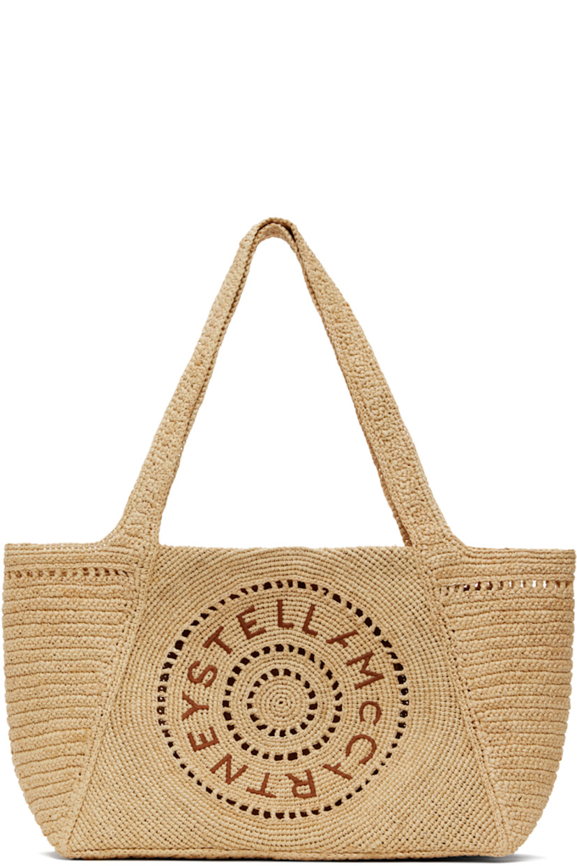 Handcrafted woven raffia tote in beige.

· Fixed shoulder straps
· Hand-embroidered logo at face
· Magnetic press-stud closure
· Patch pocket at interior
· H9" x W15.5" x D5"

Made from cruelty-free, non-animal materials.

Supplier color: Natural