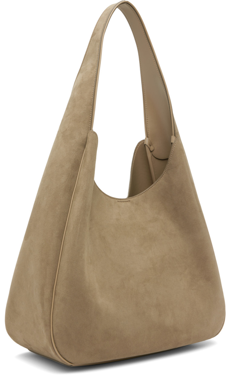 Faux-suede tote. 

· Piping throughout
· Integrated shoulder strap
· Perforated logo at face
· Magnetic press-stud closure
· Patch pocket at interior
· Buffed faux-leather interior
· H14" x W15" x D6"

Made from cruelty-free, non-animal materials.

Supplier color: Khaki