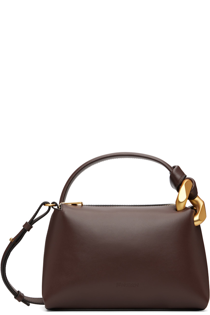 Buffed leather shoulder bag.

· Curb chain detailing at carry handle
· Adjustable and detachable crossbody strap
· Logo embossed at face
· Zip closure
· Faille lining
· H6" x W9.5" x D4"

Supplier color: Deep walnut