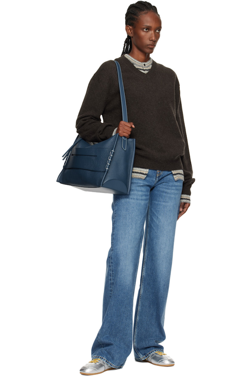Pebble-grained calfskin shoulder bag. 

· Adjustable and detachable shoulder strap
· Strap with cutout and blanket stitching at face
· Logo embossed at back face
· Zip closure
· Patch pocket at interior 
· Suede lining 
· H11.5" x W16" x D6.5"

Supplier color: Denim blue