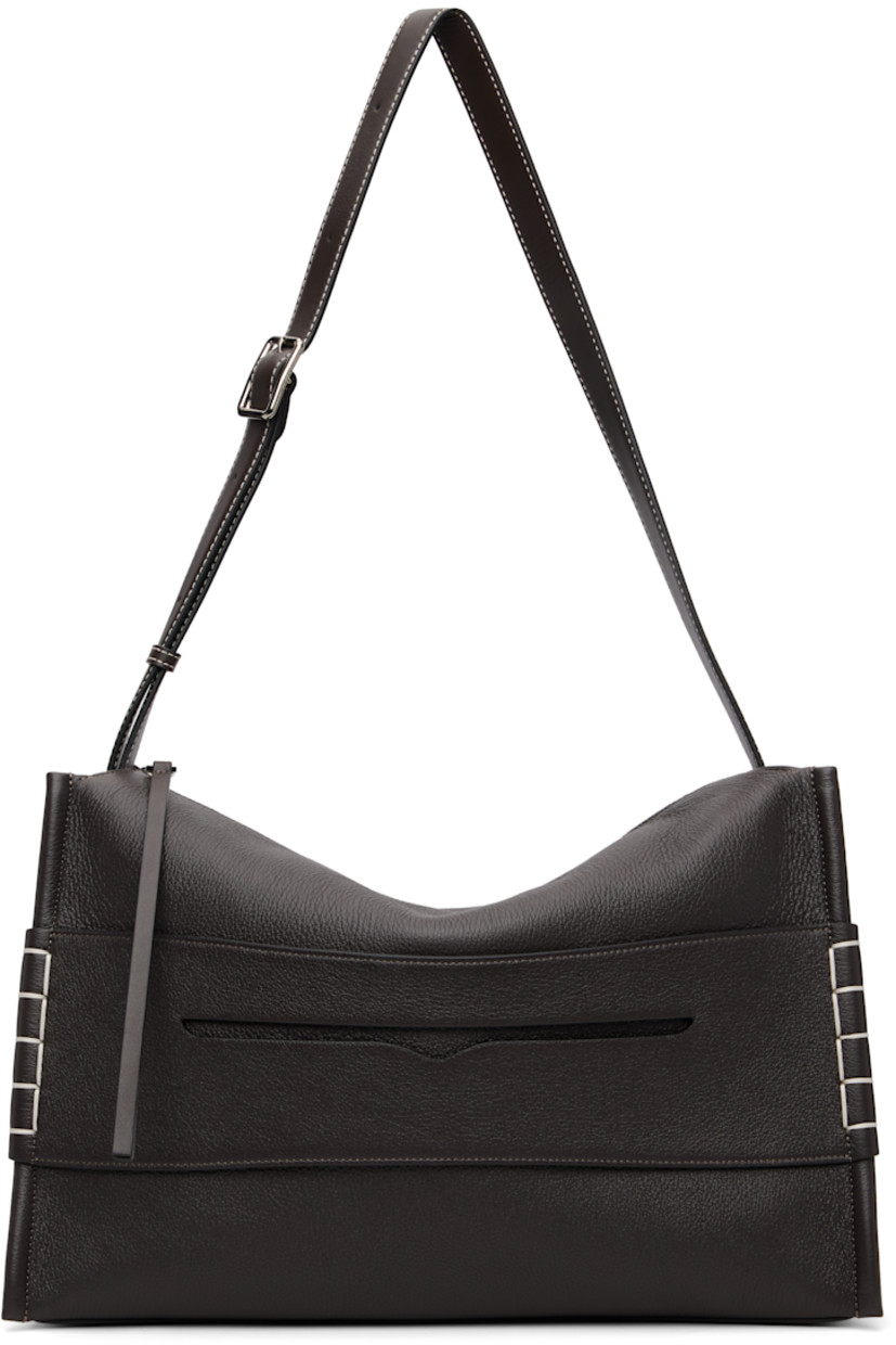 Pebble-grained calfskin shoulder bag.

· Adjustable and detachable shoulder strap
· Strap with cutout and blanket stitching at face
· Logo embossed at back face
· Zip closure
· Patch pocket at interior
· Suede lining
· H11.5" x W16" x D6.5"  

Supplier color: Chocolate brown