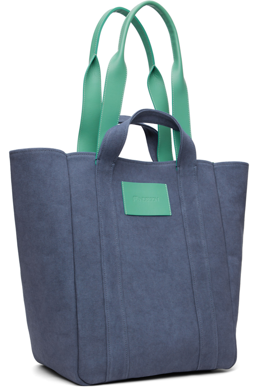 Canvas tote.

· Fading throughout
· Fixed carry handles
· Buffed leather shoulder strap
· Press-stud closure
· Patch pocket at interior
· H17" x W19" x D7"

Supplier color: Denim blue