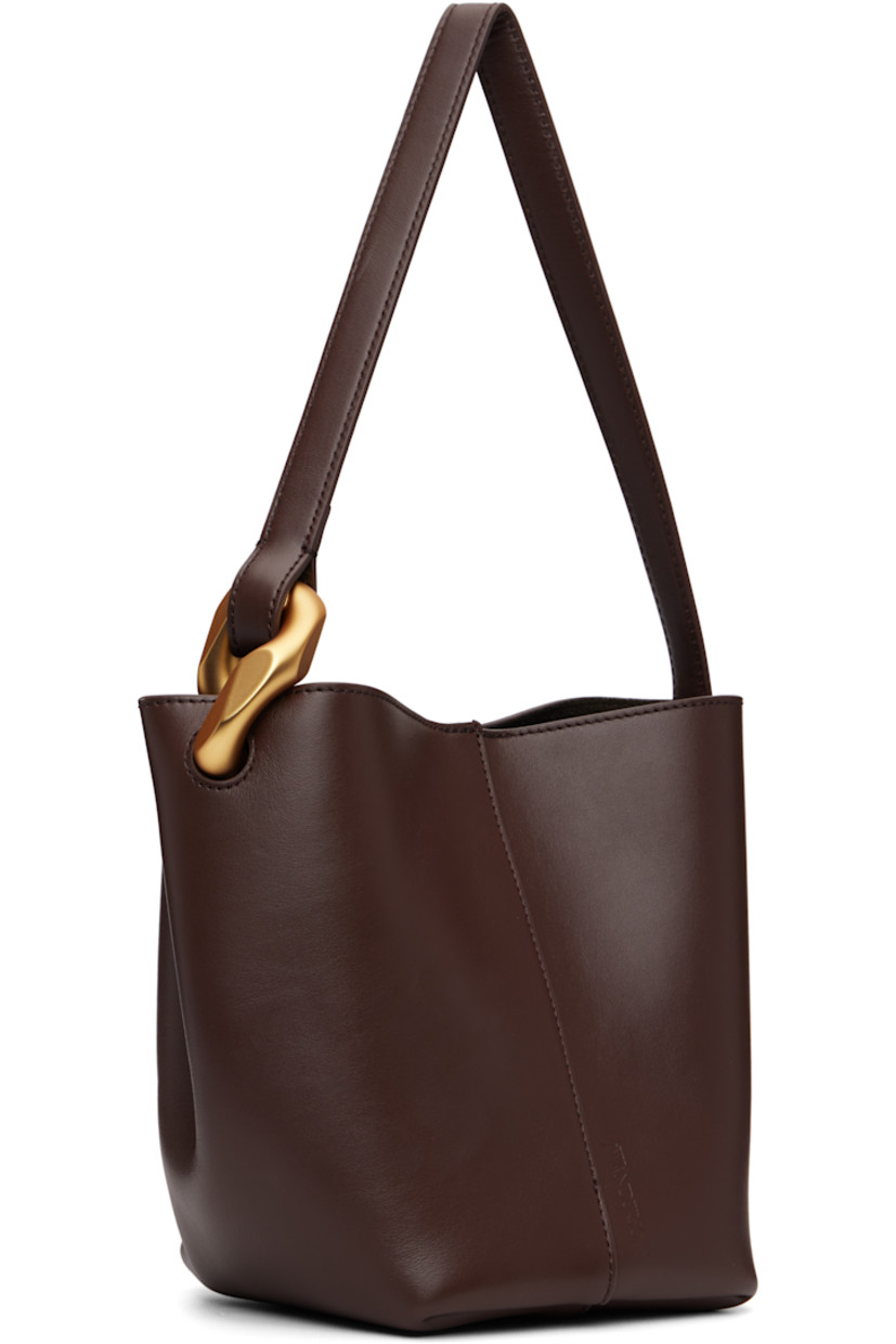 Grained calfskin tote.

· Curb chain link at fixed shoulder strap
· Logo embossed at face
· Magnetic press-stud closure 
· Patch pocket at interior
· Suede lining
· H7.5" x W9" x D5"

Supplier color: Deep walnut