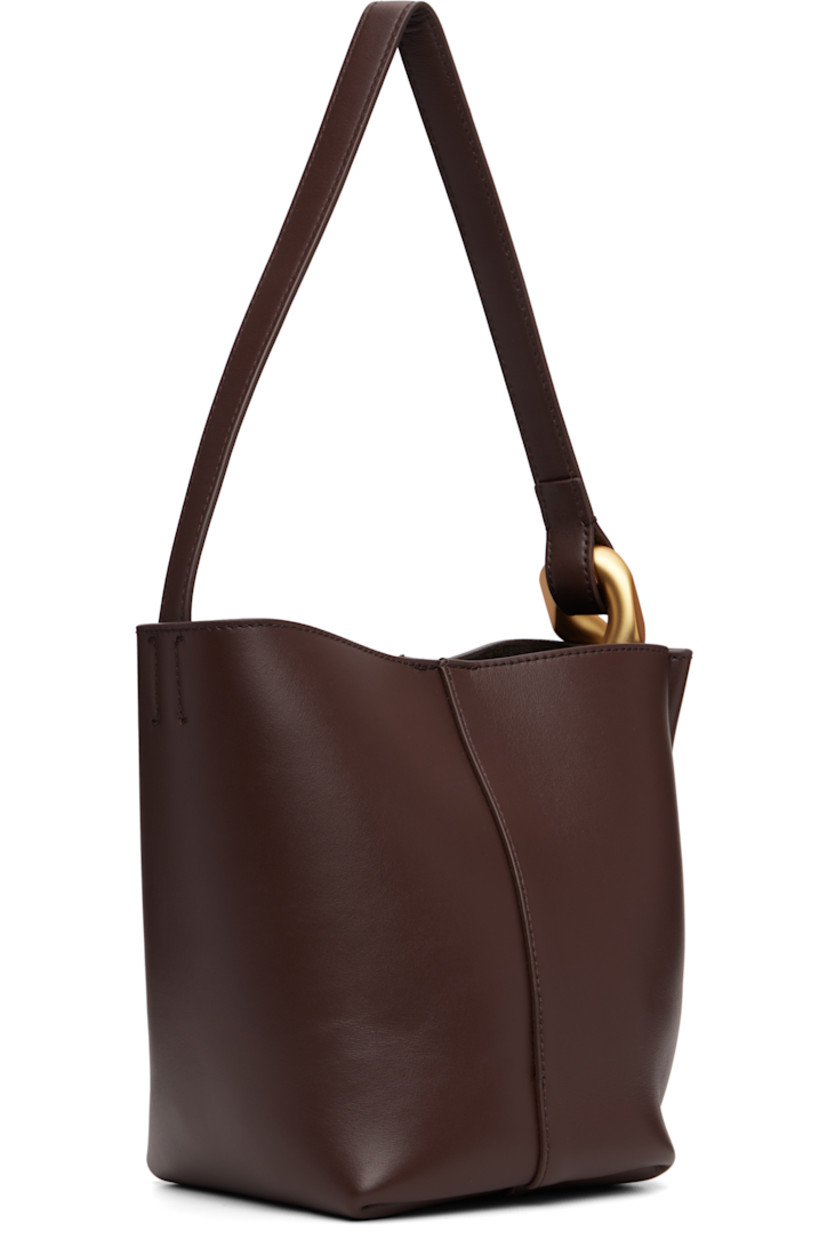 Grained calfskin tote.

· Curb chain link at fixed shoulder strap
· Logo embossed at face
· Magnetic press-stud closure 
· Patch pocket at interior
· Suede lining
· H7.5" x W9" x D5"

Supplier color: Deep walnut