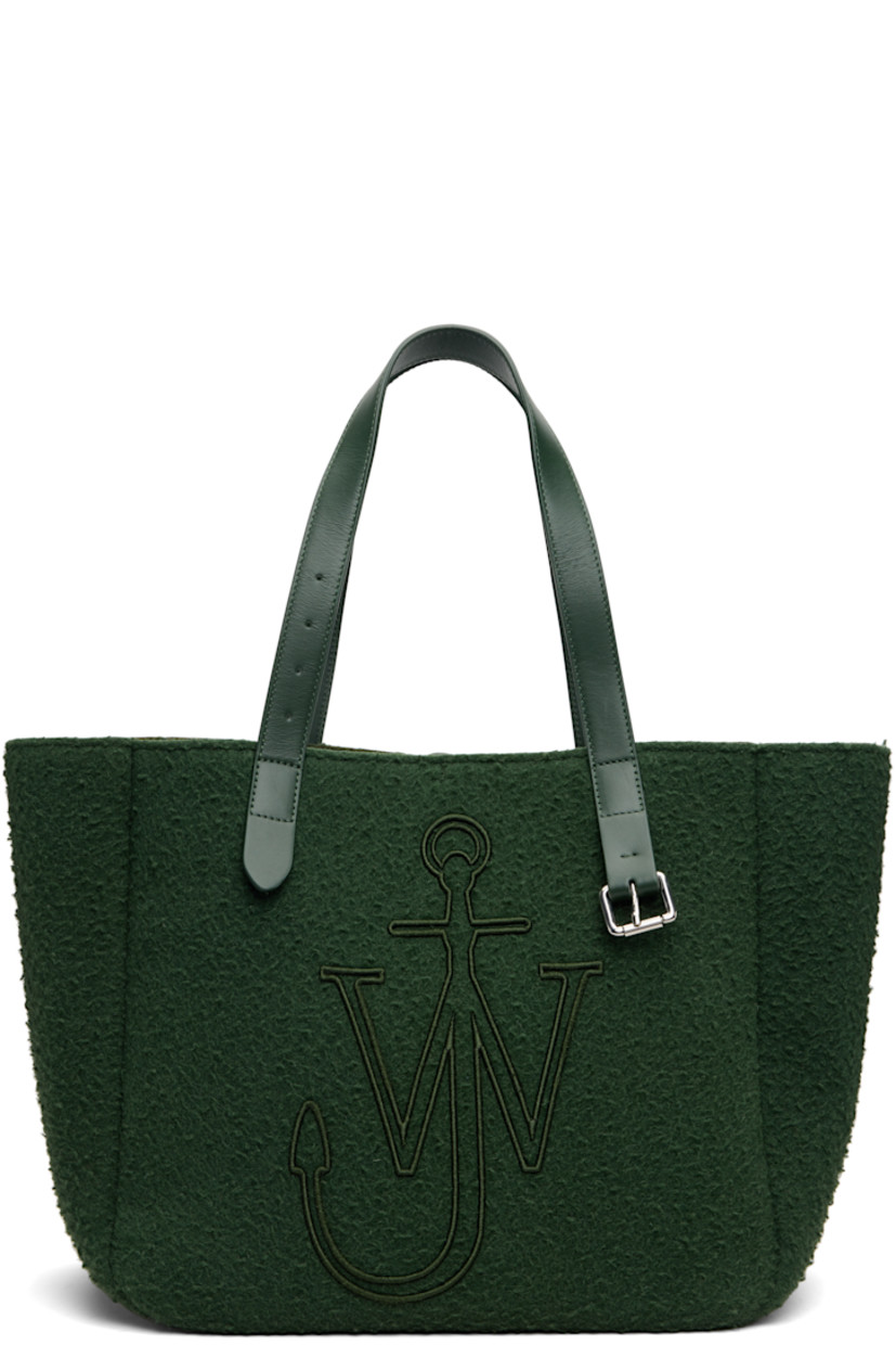 Melton tote.

· Fixed shoulder straps
· Pin-buckle hardware and embroidered logo at face
· Bumper pads at base
· Self-tie closure
· Patch pocket at interior
· H12" x W18" x D9"

Supplier color: Pine