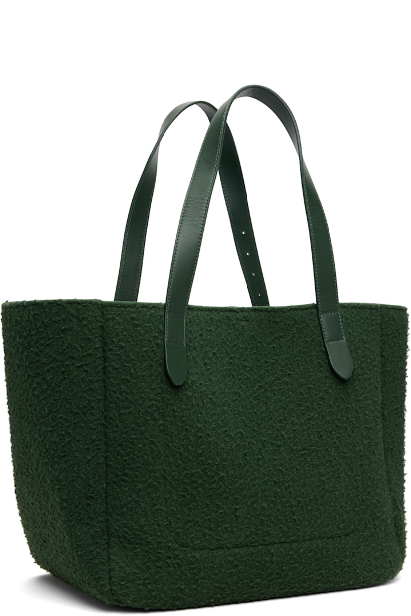 Melton tote.

· Fixed shoulder straps
· Pin-buckle hardware and embroidered logo at face
· Bumper pads at base
· Self-tie closure
· Patch pocket at interior
· H12" x W18" x D9"

Supplier color: Pine