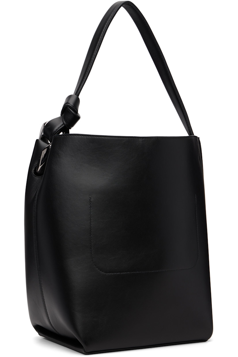 Grained calfskin tote.

· Curb chain link at fixed shoulder strap
· Logo embossed at face
· Magnetic press-stud closure
· Patch pocket at interior
· Suede lining
· H12.5" x W11" x D7"

Supplier color: Black