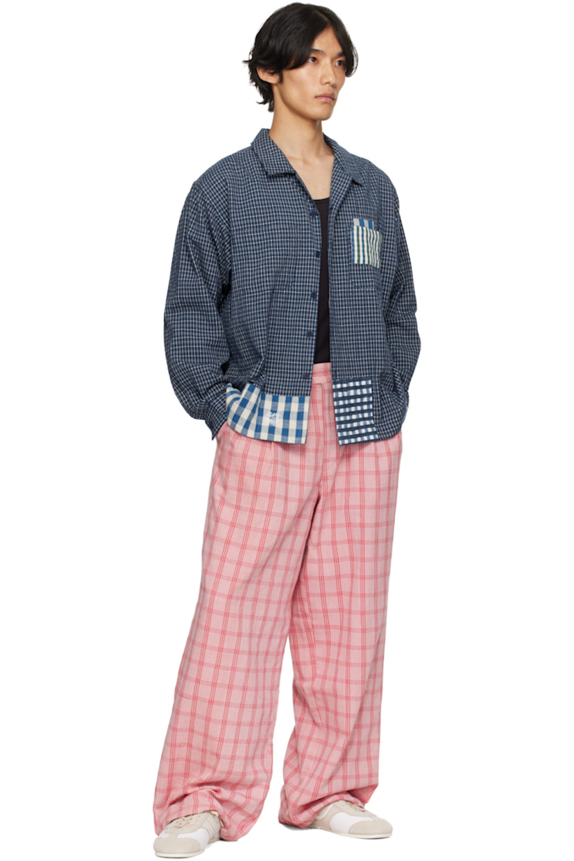 Hand-loomed plain-woven organic cotton shirt.

· Hand-block-printed and indigo-dyed check patterns
· Open spread collar
· Button closure
· Patch pocket at chest
· Embroidered logo at front hem
· Patchworking at hem and cuff
· Buttoned barrel cuffs
· Pleats at back yoke
· Corozo hardware

Supplier Color: Indigo Picnic Handloom