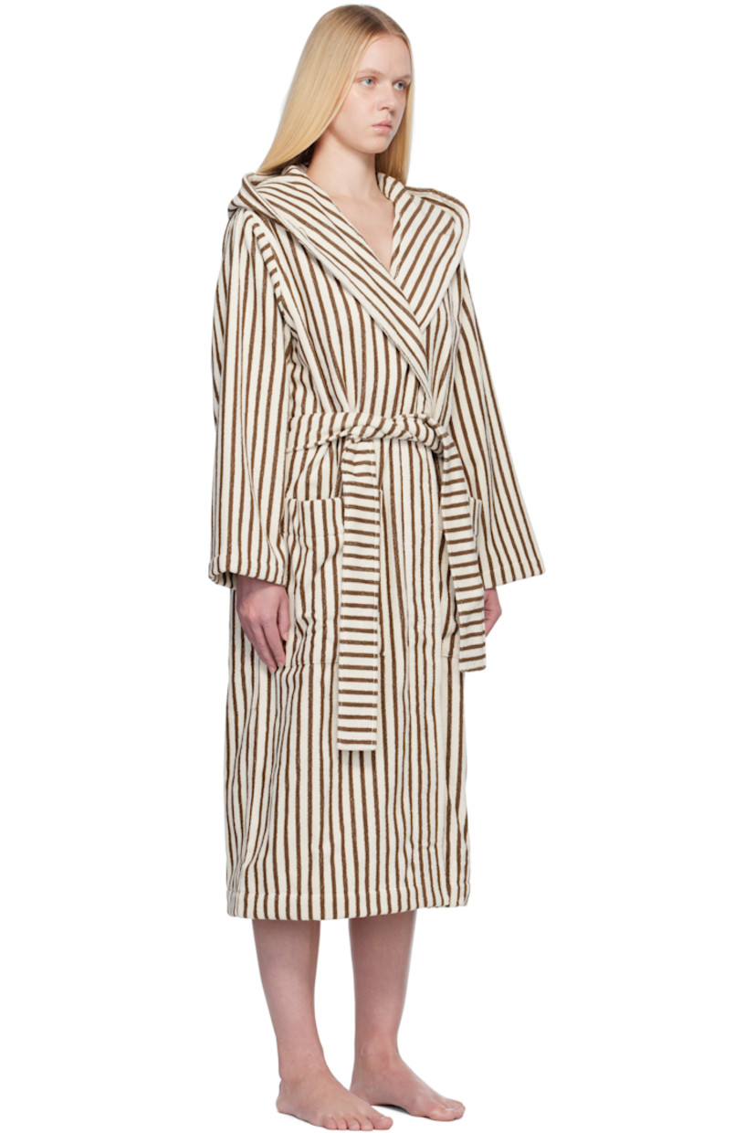 Heavyweight 385 gsm organic cotton terrycloth bathrobe. Stripes throughout.

· Certified GOTS and OEKO-TEX® Standard 100
· Hood at shawl lapel
· Open front
· Belt loops and detachable self-tie belt
· Patch pockets
· Logo flag at side seam
· Locker loop at inner collar

Supplier color: Kodiak stripes