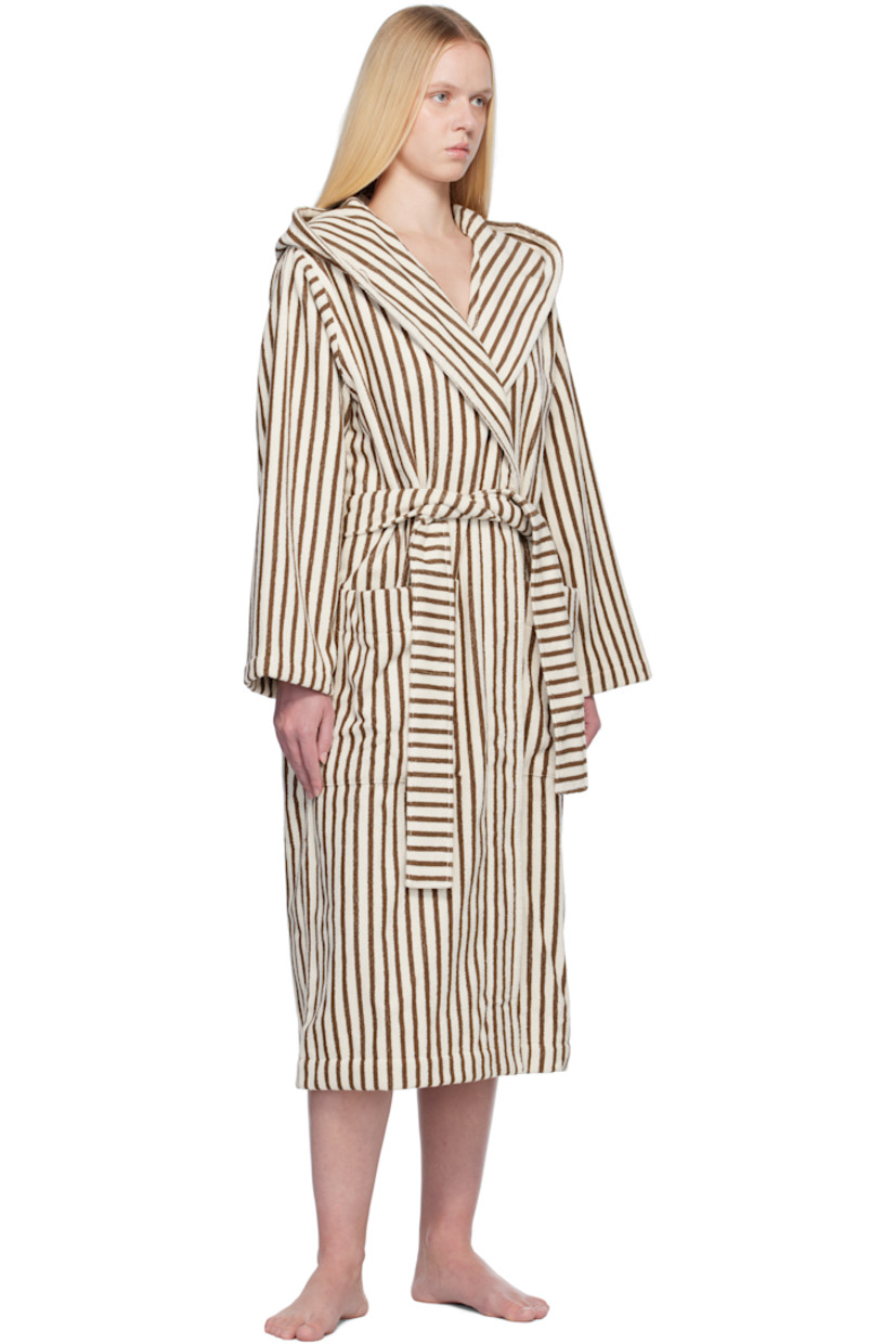 Heavyweight 385 gsm organic cotton terrycloth bathrobe. Stripes throughout.

· Certified GOTS and OEKO-TEX® Standard 100
· Hood at shawl lapel
· Open front
· Belt loops and detachable self-tie belt
· Patch pockets
· Logo flag at side seam
· Locker loop at inner collar

Supplier color: Kodiak stripes
