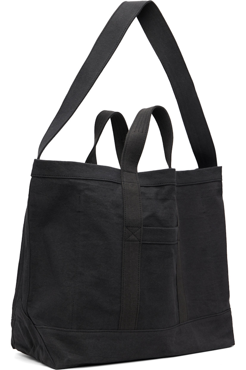 390 gsm organic cotton canvas tote.

· Garment-dyed
· Fixed carry handles and crossbody strap 
· Logo embroidered at face
· Patch pocket at back face
· Patch and zip pocket at interior
· H14" x W21" x D7"

Supplier color: Black sand/Washed black hue