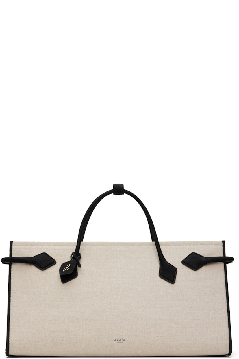 Linen-blend canvas and calfskin suede tote. 

· Press-stud tab at rolled carry handles
· Detachable logo tag at handle base
· Logo stamp at face
· Strap at sides
· Open throat
· Patch pocket at interior
· H9" x W16.5" x D6.5"

Supplier color: Noir