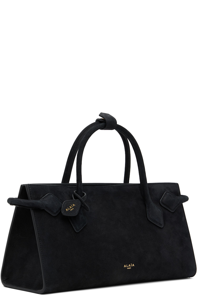 Rigid calfskin nubuck tote.

· Rolled carry handles with press-stud tab
· Detachable logo tag at handle base
· Rolled nubuck trim at sides 
· Open throat
· Patch pocket at interior
· Suede lining
· H6.5" x W12" x D4"

Supplier color: Black