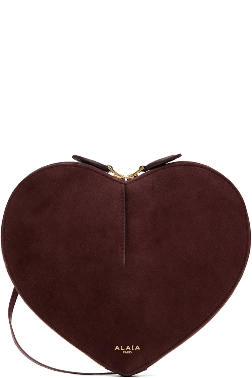 Heart-shaped rigid suede shoulder bag in burgundy. 

· Buffed goatskin trim throughout
· Adjustable crossbody strap
· Logo stamp at face
· Two-way zip closure
· Accordion panels at interior
· Buffed calfskin lining
· Silver-tone hardware
· H7.5" x W8.5" x D3"

Supplier color: Red
