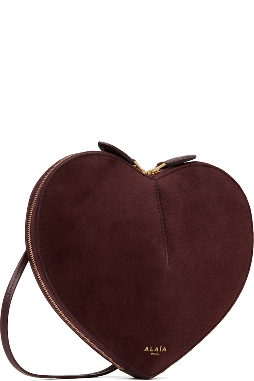 Heart-shaped rigid suede shoulder bag in burgundy. 

· Buffed goatskin trim throughout
· Adjustable crossbody strap
· Logo stamp at face
· Two-way zip closure
· Accordion panels at interior
· Buffed calfskin lining
· Silver-tone hardware
· H7.5" x W8.5" x D3"

Supplier color: Red