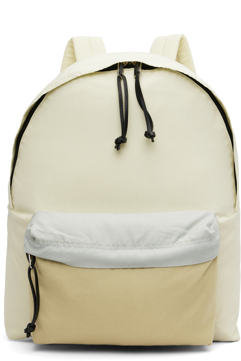 Nylon canvas backpack.

· 210 denier
· Fixed webbing and leather carry handle
· Adjustable padded shoulder straps
· Zip compartment at face
· Two-way zip closure
· Laptop compartment at interior
· Canvas lining
· H18" x W12" x D5.5"

Part of the AURALEE x AETA collaboration.

Supplier color: Ivory/Beige
