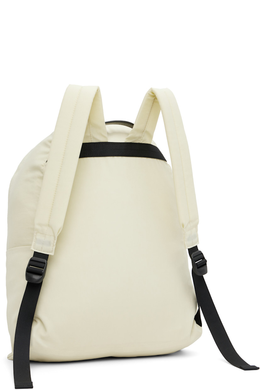 Nylon canvas backpack.

· 210 denier
· Fixed webbing and leather carry handle
· Adjustable padded shoulder straps
· Zip compartment at face
· Two-way zip closure
· Laptop compartment at interior
· Canvas lining
· H18" x W12" x D5.5"

Part of the AURALEE x AETA collaboration.

Supplier color: Ivory/Beige