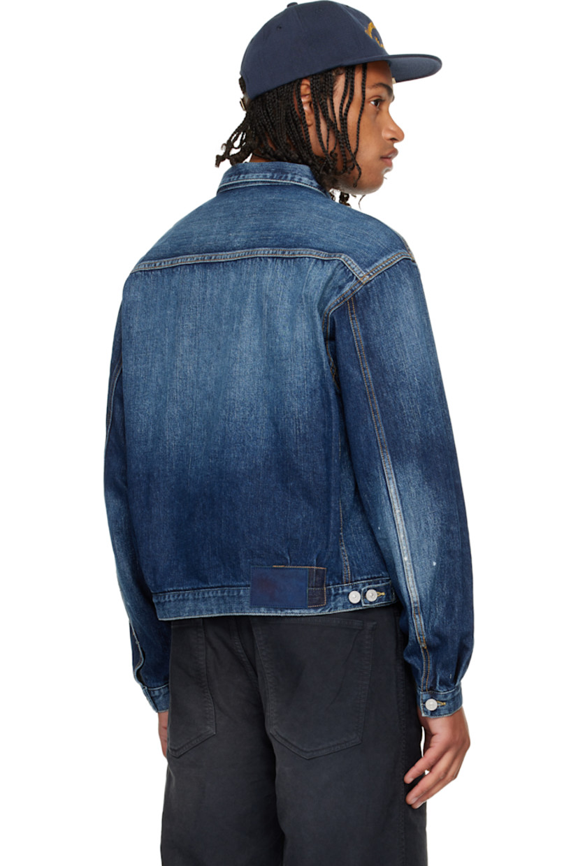 Non-stretch denim jacket.

· Fading throughout
· Spread collar
· Button closure
· Tucks at front
· Flap pockets at chest
· Seam pockets
· Buttoned barrel cuffs
· Adjustable button tabs and logo patch at back hem
· Contrast stitching in tan

Supplier color: Navy