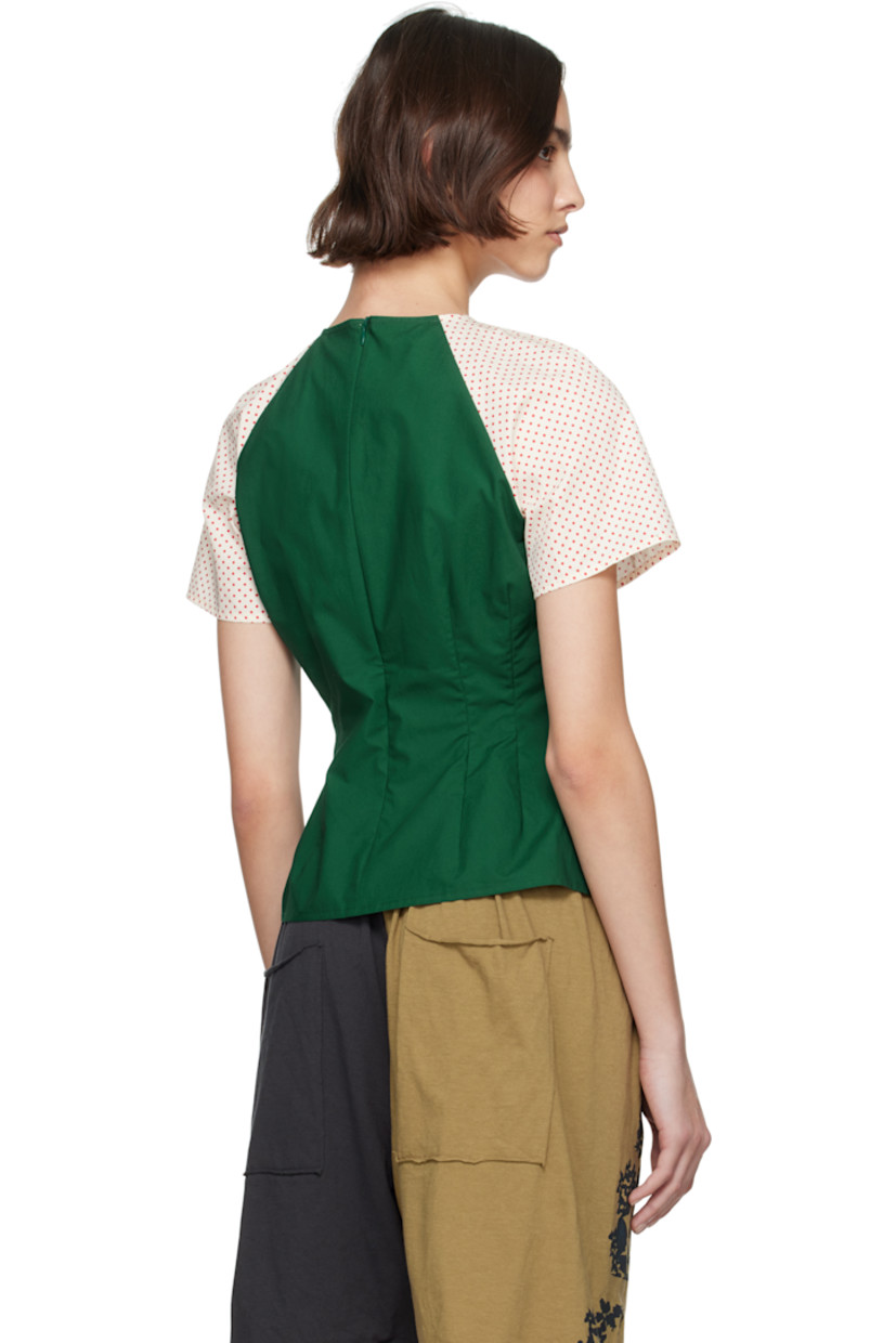 Cotton poplin blouse.  

· Paneled construction
· V-neck
· Darts at chest
· Pointed hem 
· Polka-dot pattern at raglan sleeves 
· Zip closure at back 

Supplier color: Vitamin