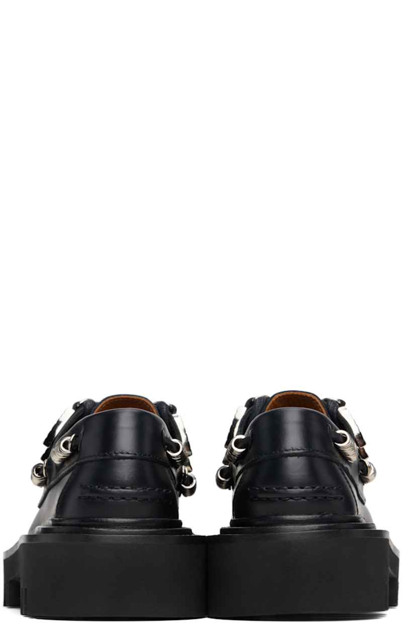 Buffed leather boat shoes.

· Moc toe
· Graphic hardware at lace-up closure
· Cord with O-rings at sides
· Pinched seam at heel counter
· Topstitching at welt
· Foam rubber midsole
· Treaded rubber sole

Supplier color: Black