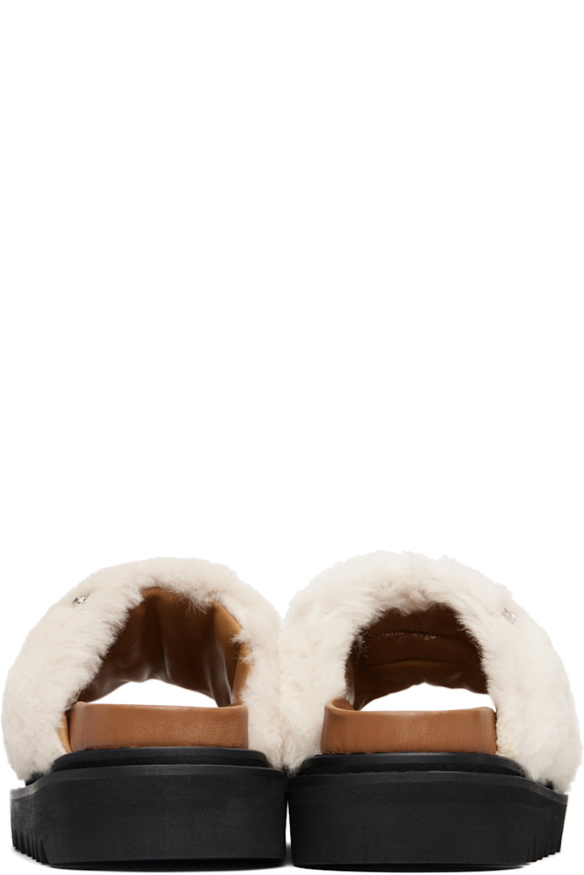 Shearling slippers. 

· Engraved graphic studs throughout 
· Open toe 
· Logo stamp at molded footbed
· Treaded foam rubber sole
· Platform: H1.5"

Supplier color: White fur