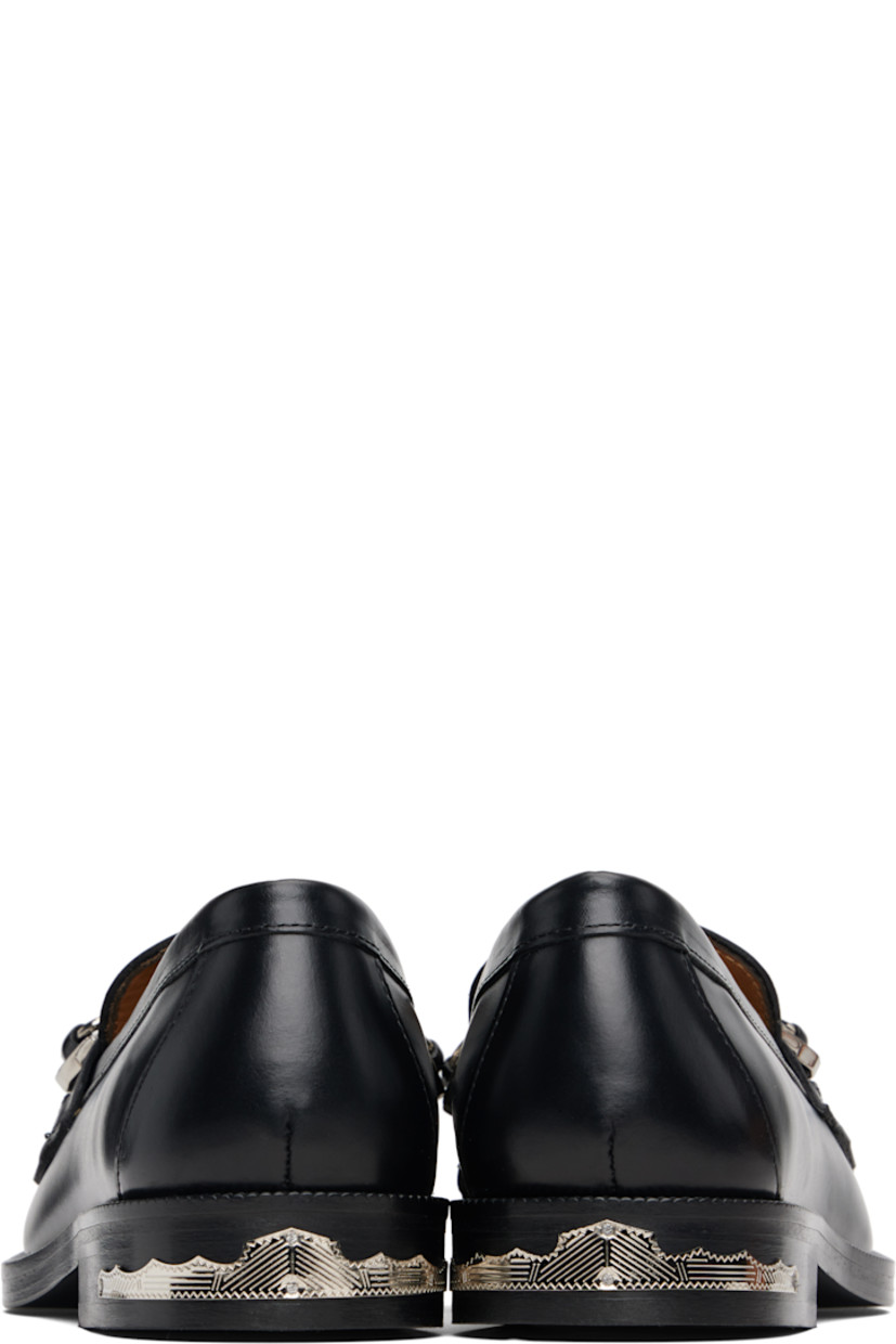 Polished leather loafers.

· Moc toe
· Tassels and strap with graphic hardware at vamp
· Serrated detailing at welt
· Plaque at heel
· Stacked leather heel with rubber injection
· Leather sole

Supplier color: Black