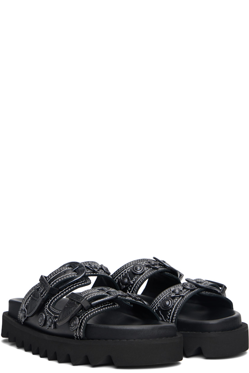 Buffed leather flats sandals.

· Graphic hardware throughout
· Open toe
· Pin-buckle straps at vamp
· Logo stamp at molded footbed
· Treaded rubber sole
· Contrast stitching in white

Supplier color: Black