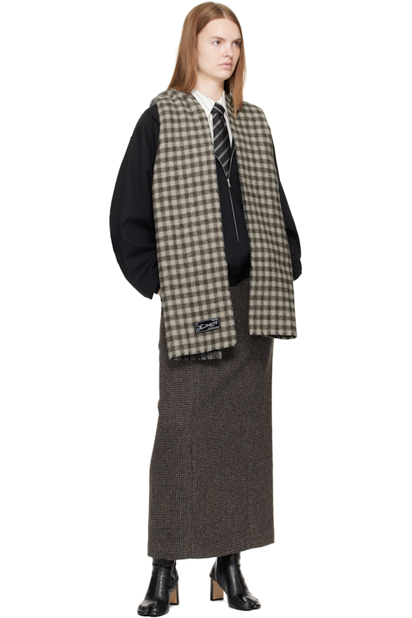 Rectangular double-faced knit wool-blend scarf.

· Jacquard check pattern throughout 
· Logo patch at end
· L81" x W15"

Supplier color: Grey double faced check