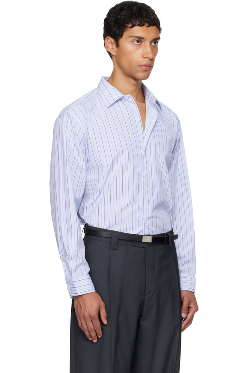 Cotton poplin shirt.

· Stripes throughout
· Spread collar
· Button closure
· Shirttail hem
· Dropped shoulders
· Adjustable buttoned barrel cuffs
· Box pleat at back yoke

Available exclusively at SSENSE.

Supplier color: Blue regent stripe