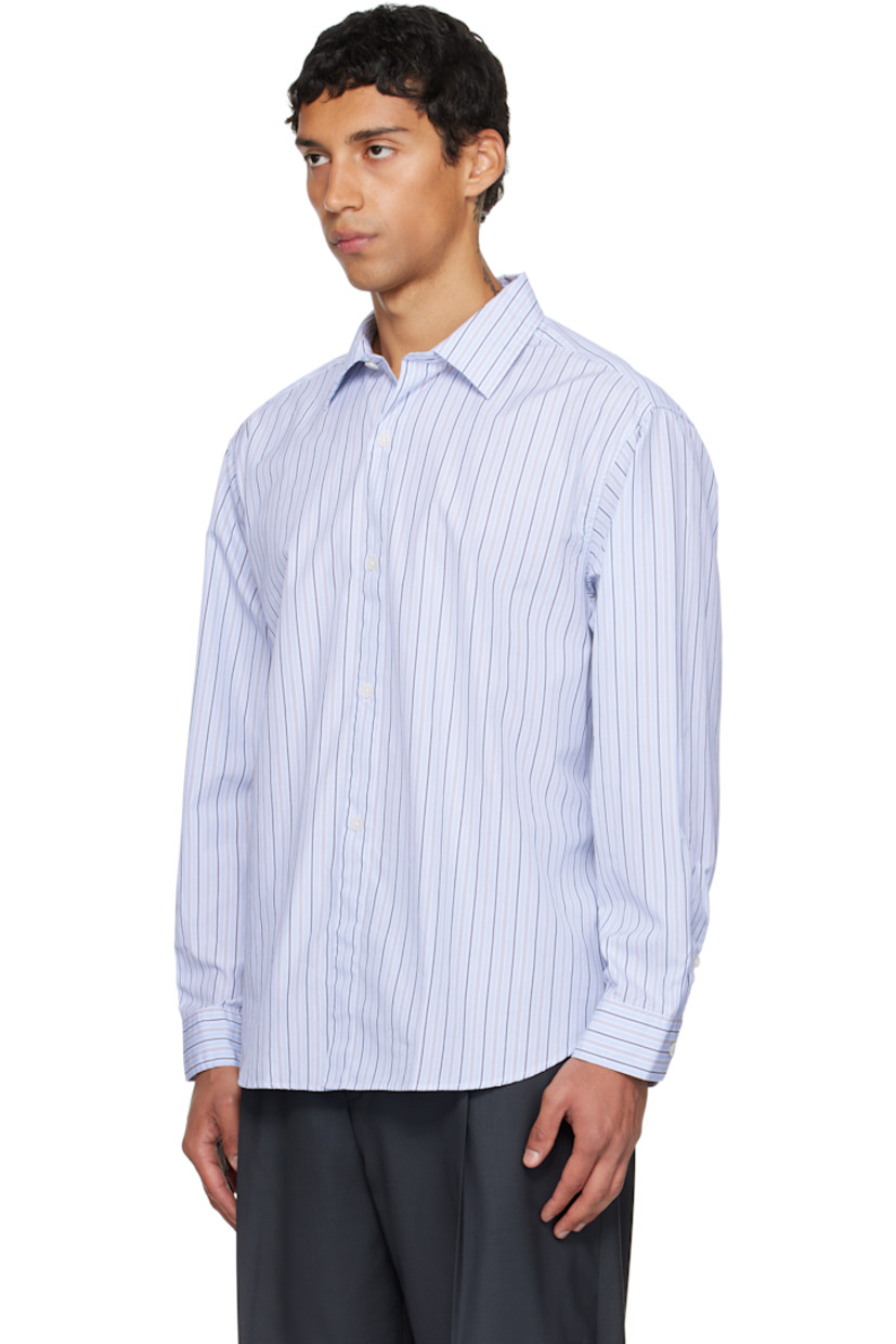 Cotton poplin shirt.

· Stripes throughout
· Spread collar
· Button closure
· Shirttail hem
· Dropped shoulders
· Adjustable buttoned barrel cuffs
· Box pleat at back yoke

Available exclusively at SSENSE.

Supplier color: Blue regent stripe