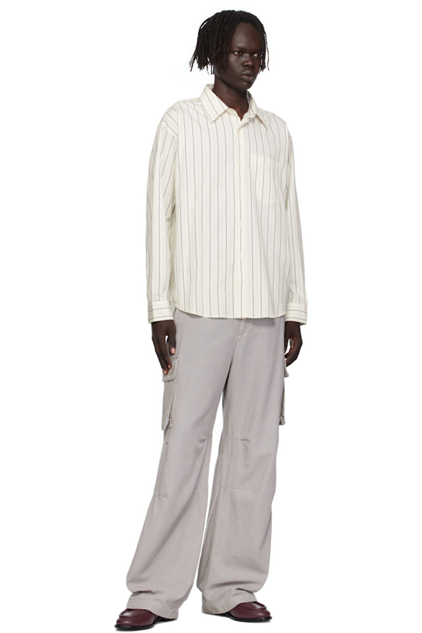 Deadstock cotton poplin shirt.

· Stripes throughout
· Spread collar
· Button closure
· Patch pocket at chest
· Shirttail hem
· Adjustable buttoned barrel cuffs
· Box pleat at back yoke

Available exclusively at SSENSE.

Supplier color: Fine weave stripe